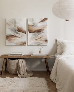 a bedroom with two paintings on the wall