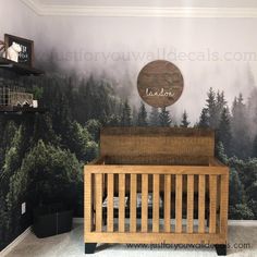 a wooden crib in front of a forest mural