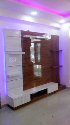 an empty room with some shelves and lights on the wall, in front of a purple light