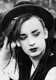 black and white photograph of a woman with dreadlocks on her head wearing a hat