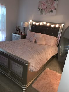 a bedroom with a large bed and pink rugs on the floor in front of it