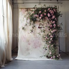 the backdrop is covered with pink roses and greenery