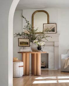 a living room with white walls and wood flooring next to a fire place in the fireplace