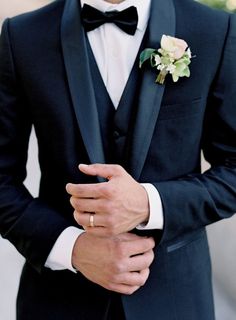 a man in a tuxedo with a flower on his lapel and a boutonniere