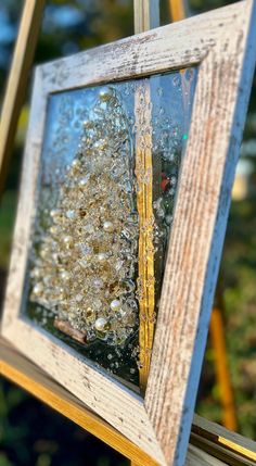 an old wooden frame with some glass on it and the reflection of a tree in it