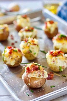 small baked potatoes with bacon and cheese on a baking sheet, ready to be eaten