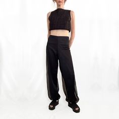 These true vintage black chiffon pants are perfect for Summer nights out. Likely made in the 70s from a lightweight, opaque nylon overlaid with a sheer chiffon nylon fabric, exuding a delicate and airy vibe. Featuring a high-waisted fit with slightly stretchy waistband these pants offer a sleek, smooth waist with relaxed, loose fit legs, tapering slightly toward gathered cuffs at the ankles, creating a romantic subtle blousy bubble effect. Blending vintage harem pant influences with a modern min Sheer Black Bottoms, Chic Black Sheer Pants, Elegant Mesh Bottoms For Evening, Sheer Wide Leg Evening Bottoms, Sheer Wide Leg Bottoms For Evening, Sheer High Waist Bottoms For Evening, Black Sheer Pants For Spring, Sheer Black Full-length Bottoms, Evening Sheer High-waist Bottoms