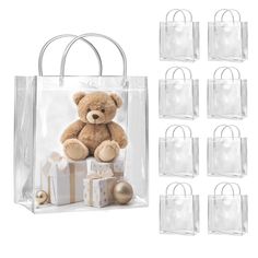 a teddy bear sitting on top of a gift bag next to other bags and presents