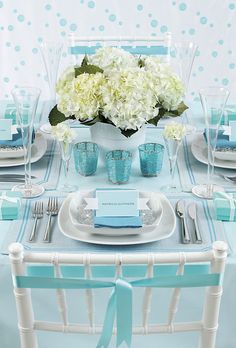 the table is set with blue and white plates, silverware, and napkins