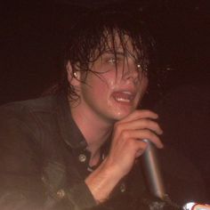 a man with wet hair holding a microphone