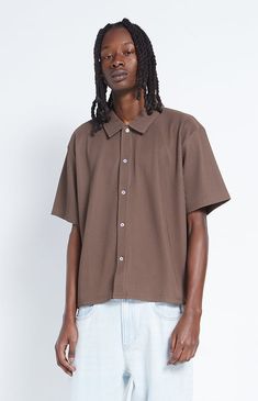 Keep things classy this season with the Ribbed Woven Button Down Shirt from PacSun. This shirt features a button-down front closure, a collared neckline, short sleeves, and a boxy, relaxed fit. 


	Button-down front closure
	Collared neckline
	Short sleeves
	Boxy fit
	PacSun branding
	Model is wearing a medium
	Model Measurements: 6'2” Height, 28" Waist, 34” Inseam Pacsun Mens, My Mobile Number, Brown Shirt, Exclusive Collection, Model Measurements, Pacsun, Cool Style, Button Downs, Button Down Shirt