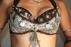 a close up of a woman's bra with chains and beads on her chest