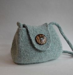 a small blue purse with a button on it