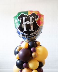 Lasts 1 to 2 days. See Longevity Notes. Some items are inflated with helium. Some items are inflated with air. Some items are inflated with air. This item is Ready-To-Party™. Handcrafted piece. May vary from picture. Features Create a statement for your kids Harry Potter themed birthday party with our floating arch and column set. This includes a Hogwarts Shield themed floating balloon arch and matching column with a Hogwarts Shield themed mylar balloons to make a Harry Potter birthday party extra fun. This set is Ready-To-Party™. Comes inflated and assembled. Simply unbag and enjoy. Details FLOATING ARCH Color Palette:Balloon - Mahogany, Brass Gold, Lemon Spritz, BlackFoil - Hogwarts Shield , Gold Orbs Finishing:tied to ribbon and weight Dimensions:H (top of arch) - approx. 8.5ftH (under Lemon Spritz, Bright Balloons, Floating Balloons, Harry Potter Kids, Sweets Table, Harry Potter Birthday Party, Harry Potter Birthday, Balloon Columns, Mylar Balloons