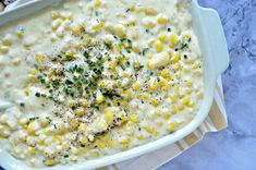 a white dish filled with corn on the cob