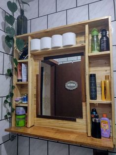 a bathroom mirror sitting on top of a wooden shelf