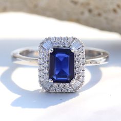 an engagement ring with a blue sapphire surrounded by white diamond halos and surrounding diamonds