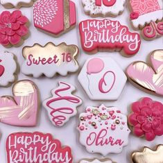 decorated birthday cookies are displayed on a white tablecloth with pink and gold accents, including hearts, flowers, and balloons