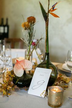 the table is set with flowers and place cards for guests to sit down at it