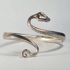 **Please note that we dispatch on Tuesdays unless special delivery express option is paid for** Sterling silver snake bangle. Original design hand carved in wax by Richard then lost wax cast into solid sterling silver. If you desire a different gem to emeralds, please get in touch. We can offer any stone for this design, from onyx straight through to diamond. The bangle size is slightly adjustable as it is a little flexible. First class post included. Afro Jewelry, Snake Ring Gold, Silver Snake Bracelet, Snake Bangle, Silver Cuff Bangle, Wrap Bangles, Snake Jewelry, Snake Bracelet, Snake Ring