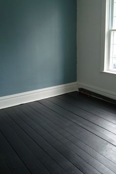 empty room with hard wood flooring and blue painted walls in the corner, along with white trim