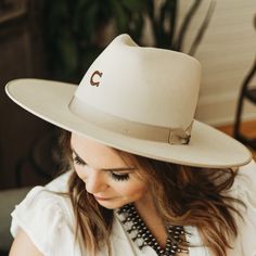 This gorgeous hat is giving us all of the Western fashion vibes! The Desert Drifter by Charlie 1 Horse features wool felt material, a pinched profile, a 3 3/4 inch wide flat brim, and a crown that measures 4 1/2 inches. The hatband is a ribbon trim that coordinates the trimmed brim. This genuine Charlie 1 Horse hats bears the brand "C," a sign that you are getting a quality made authentic Charlie 1 Horse hat. Please note that all hats are branded by hand by a hatmaker at Charlie 1 Horse, with th Charlie 1 Horse Hat, Charlie Horse, Hat With Ribbon, Trendy Boutique Clothing, Fashion Vibes, Giddy Up Glamour, Trendy Boutique, Felt Material, Western Hats