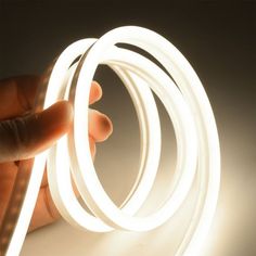 a hand holding a white light up tube