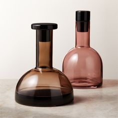 two glass bottles sitting next to each other on a table