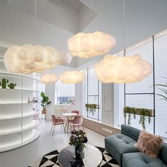 a living room filled with furniture and lots of clouds hanging from the ceiling above it