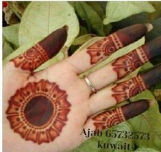 the hand is decorated with henna designs on it's fingers and palm leaves