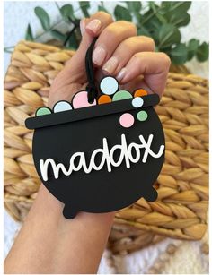 a person holding up a black sign with the word madabox on it in front of a basket