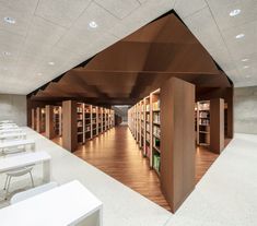 an empty library with many bookshelves and tables