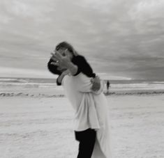 a man holding a woman on the beach