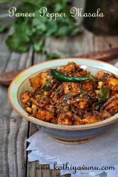 paneer pepper masala in a bowl on a wooden table with a spoon and napkin