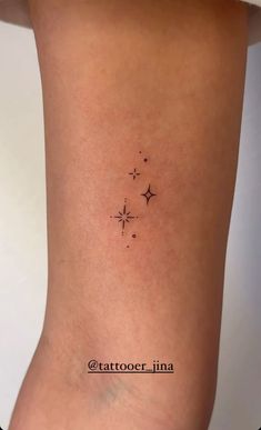 a small star tattoo on the back of a woman's leg, it is black and white