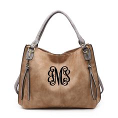 This bag is just super stylish! Rivers is a large Satchel Handbag! This bag offers a zipper top closure with large side pockets with extra the touch of adorable tassels. You will not be able to get enough of the super soft vegan leather! Adding personalization just rounds out the final touch to any outfit! ** Shown here in Distressed Tan with black thread and interlock font** Other thread colors available upon request, just ask we are sure to have it! Distressed Side Pocket Tote Dual handles Zip Modern Leather Bag With Monogram, Modern Monogram Leather Bag, Leather Monogram Shoulder Bag For Everyday Use, Monogram Leather Bag In Rectangular Shape, Rectangular Leather Bag With Monogram, Rectangular Leather Monogram Bag, Leather Monogram Bag For Everyday Use, Monogram Leather Bags For Everyday Use, Everyday Leather Bag With Monogram