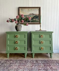 two green dressers with gold handles and knobs in front of a painting on the wall