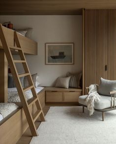 a bedroom with bunk beds, a chair and a ladder to the bed in it