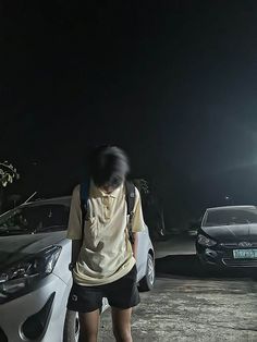 a woman standing next to a white car at night