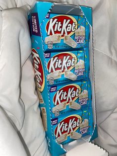 three kitkats stacked on top of each other in a blue box with white sheets