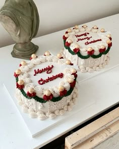 two cakes sitting on top of a white table