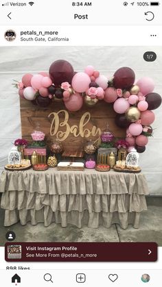 a table with balloons, cake and other items on it for a baby shower party