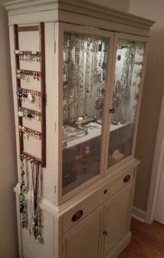 an armoire with lots of jewelry on it