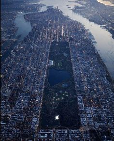 an aerial view of a large city with lots of buildings and water in the foreground