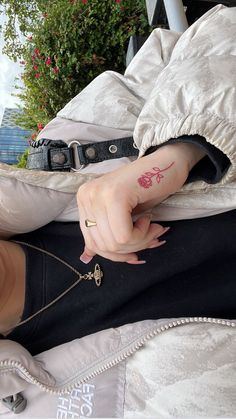 a woman with a tattoo on her left arm holding onto a chain that is attached to her wrist