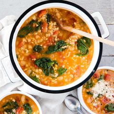 two bowls of soup with spinach, carrots and other vegetables