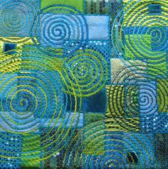 a close up view of a quilt made with blue and green circles