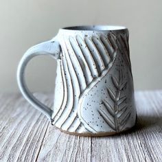 a white coffee mug sitting on top of a wooden table