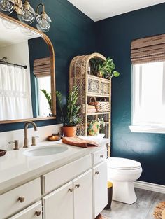 a bathroom with blue walls and white cabinets