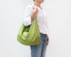 "Lovely lime green hobo bag in stonewashed linen with leather strap, perfect for summer. It is a very comfy shoulder bag, oversized but very lightweight. Also, the wide leather strap does not stick to your shoulder. This shoulder bag is lined with a lime and white striped fabric 100% cotton. Its 100% linen outer fabric is very cool and pleasant for the summer. This hobo bag is perfect for any time of day and adds style to any outfit. * Materials: - Outside: 100% stonewashed linen. Lime green col Versatile Green Canvas Bag, Spring Green Canvas Shoulder Bag, Green Canvas Shoulder Bag For Spring, Green Spring Shoulder Hobo Bag, Green Hobo Bag For Spring Travel, Summer Linen Shoulder Bag For Everyday Use, Green Hobo Bag For Travel And Spring, Everyday Green Hobo Bag, Spring Travel Green Hobo Bag